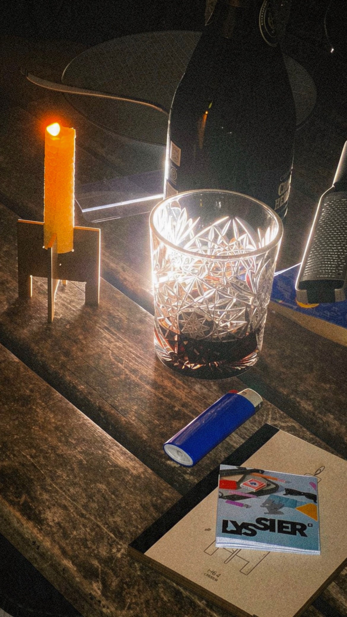Lyssier H64 candleholder from brass with a hand rolled beeswax candle glowing on a wooden table during a late evening gathering.