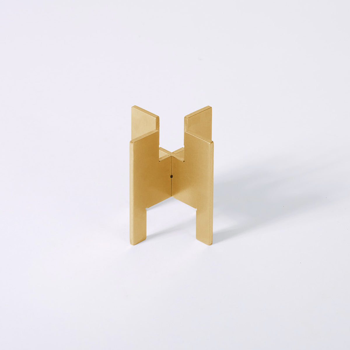 Minimalist portable Lyssier H64 candleholder in solid brass, made from two interlocking pieces. Shown assembled with the taper candle side facing up.