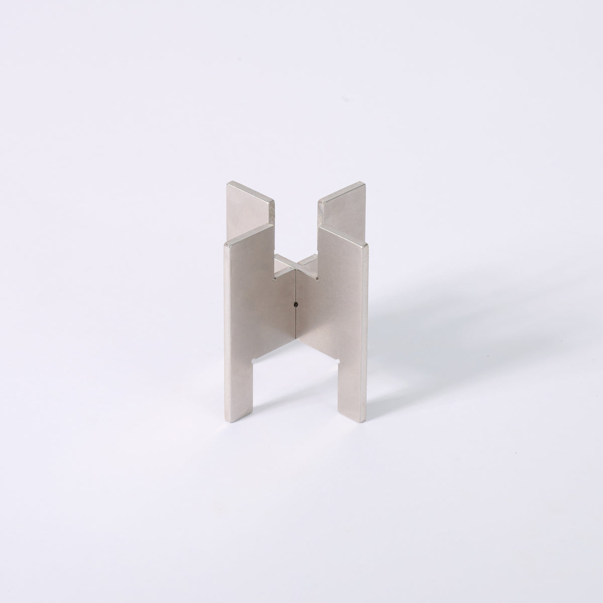 Minimalist portable Lyssier H64 candleholder in solid stainless steel, made from two interlocking pieces. Shown assembled with the taper candle side facing up.