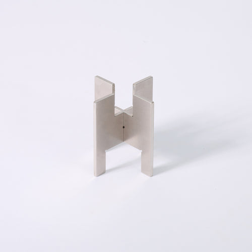 Minimalist portable Lyssier H64 candleholder in solid stainless steel, made from two interlocking pieces. Shown assembled with the taper candle side facing up.